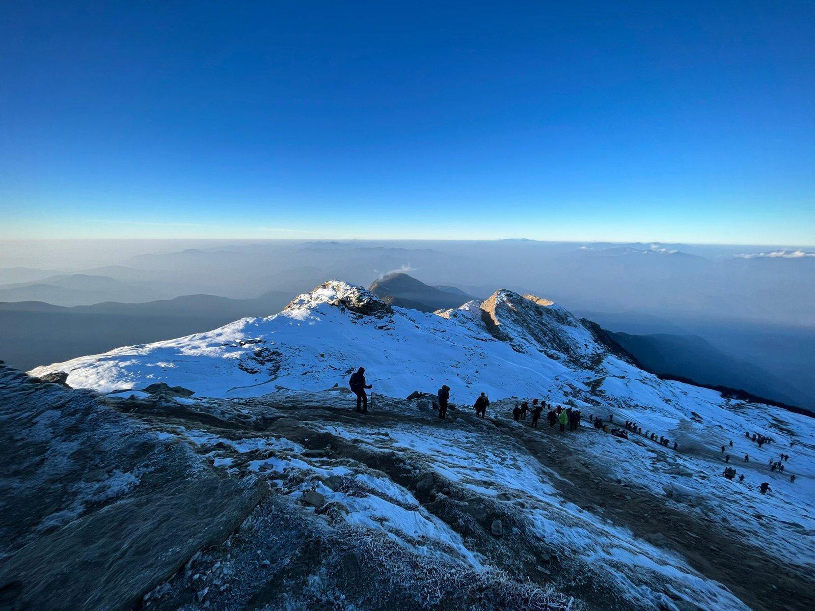 a group of people standing on top of a snow covered mountain